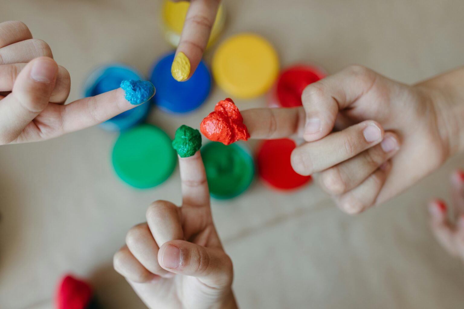 Children exploring creativity with colorful finger painting. Close-up of hands and paint.